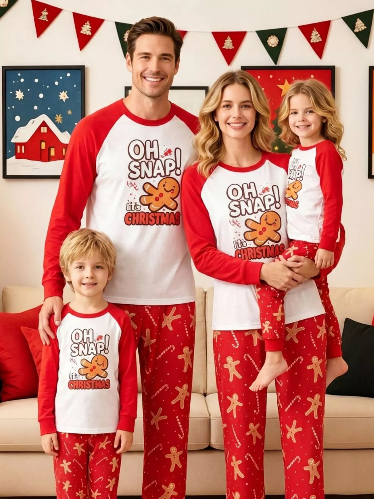 Family wearing matching white Oh Snap gingerbread graphic tops with red sleeves and red printed pajama pants.