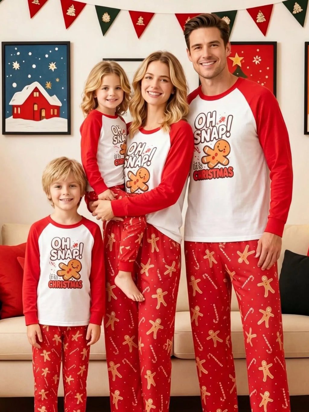 Family wearing matching white Oh Snap gingerbread graphic tops with red sleeves and red printed pajama pants.