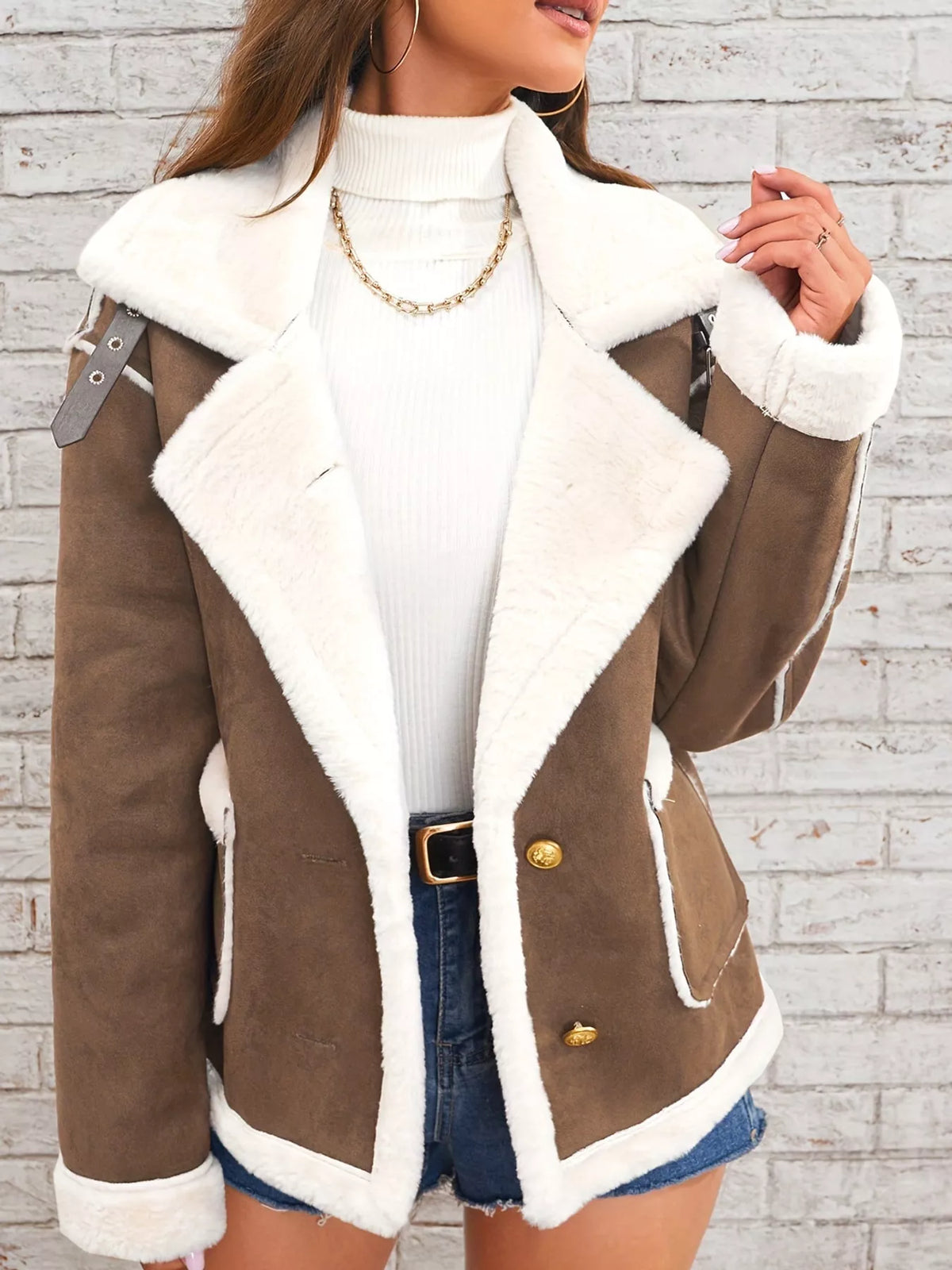 Brown jacket with wide white plush lapels, contrast trim and front pockets, front view modeled holding the lapel.