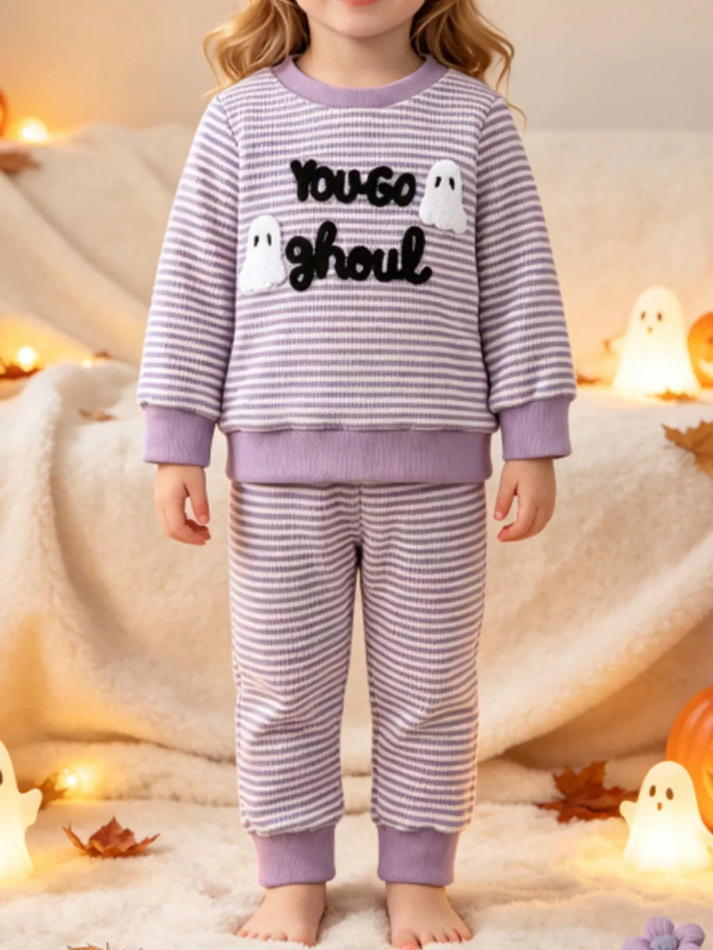 Purple striped ghost graphic pajama top and matching pants worn by a child