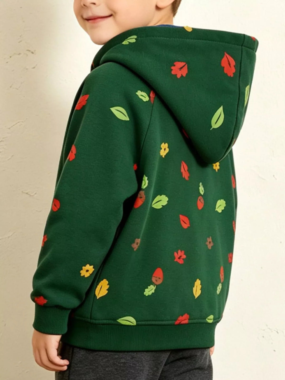 Children’s green hedgehog-print hoodie with contrasting blue hood lining worn by a child