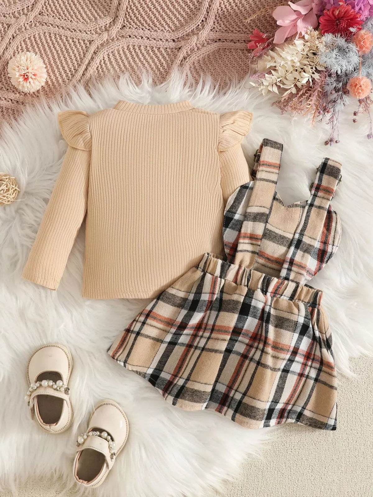 Back flat lay of the cream top and beige plaid suspender skirt.