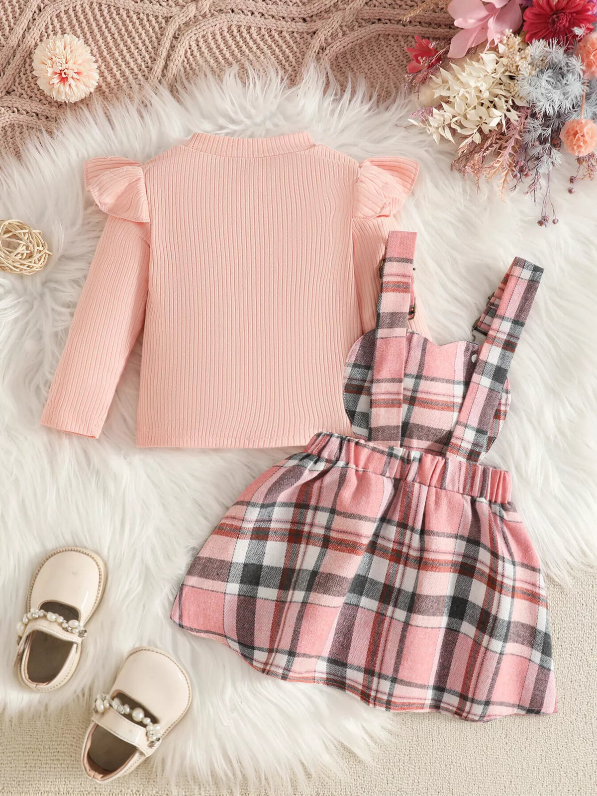 Back flat lay of the pink top and pink plaid suspender skirt.