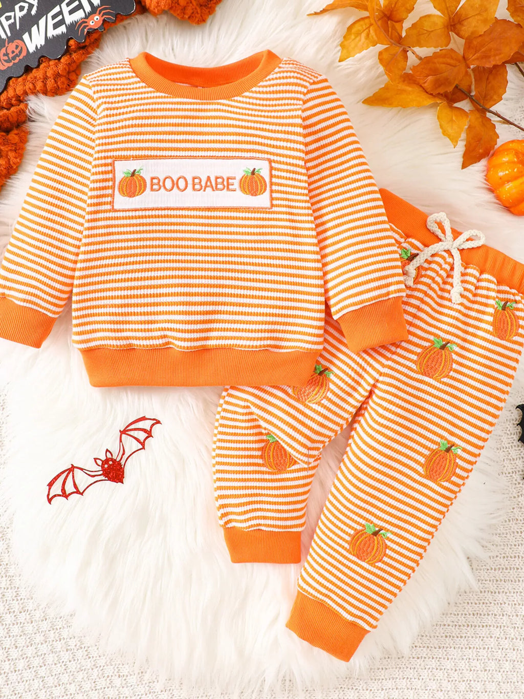 Orange striped BOO BABE pajama top and matching Halloween-print pants displayed flat
