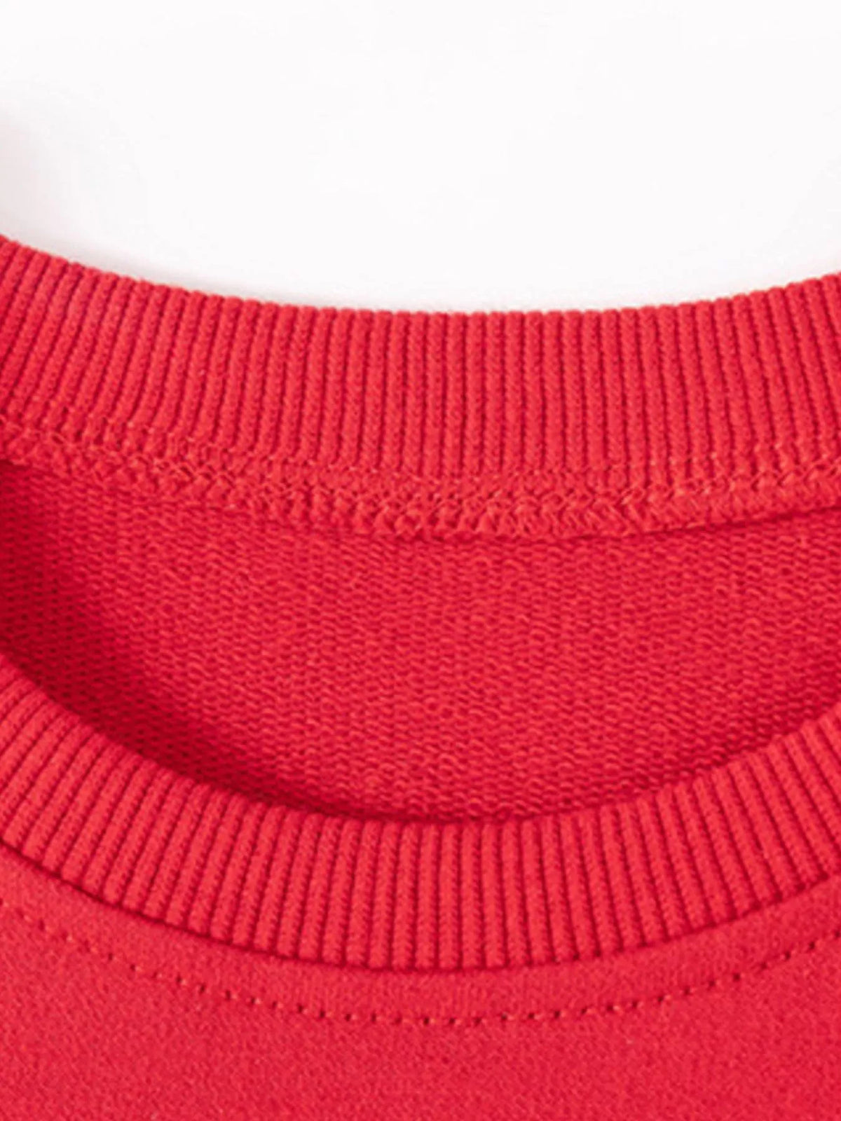 Close-up of the red sweatshirt's ribbed crew neckline.