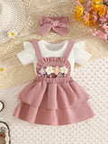 White baby bodysuit with dusty pink tiered suspender skirt, flower appliques and matching bow headband.