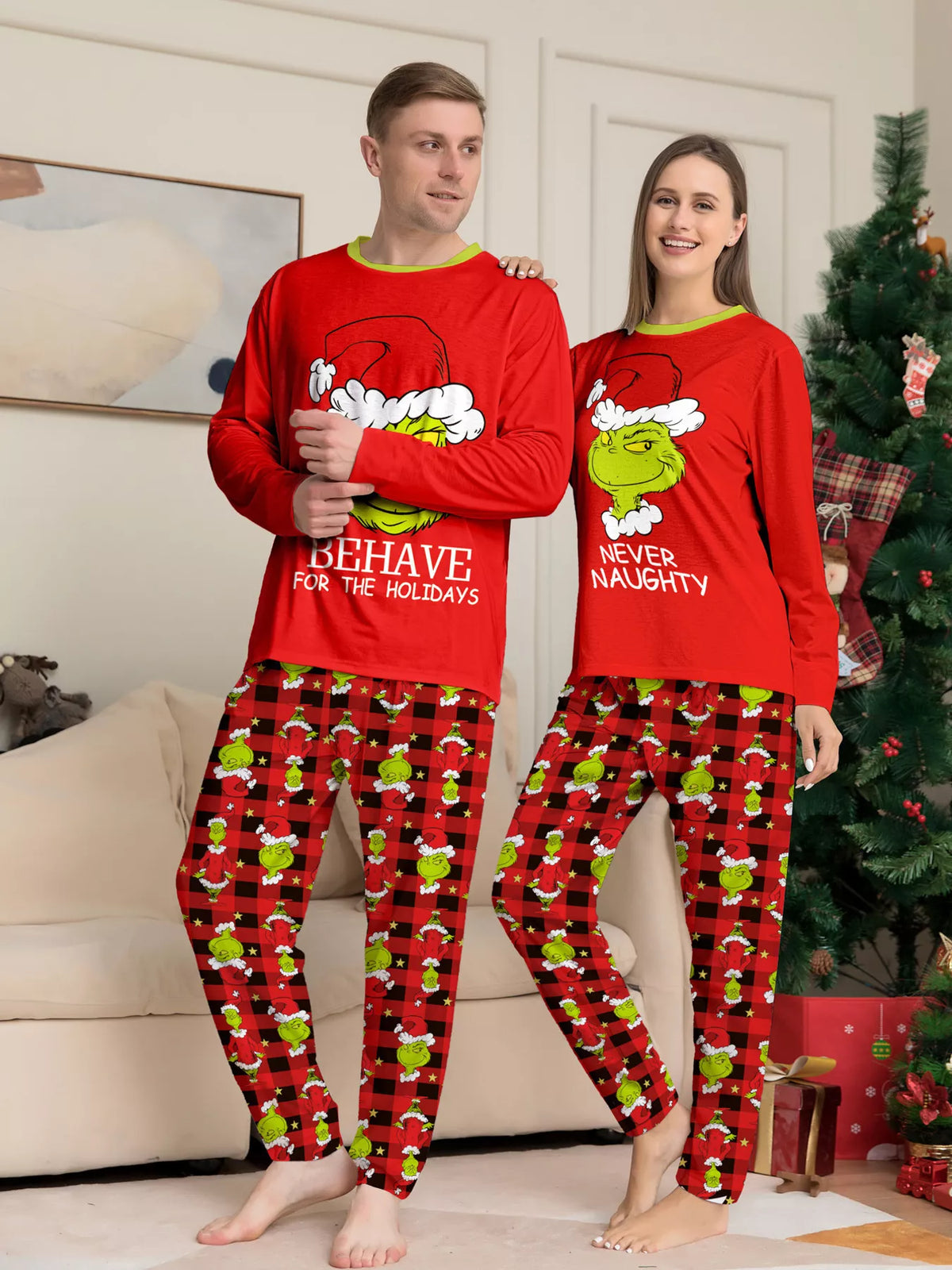 Red matching family Grinch graphic pajama top and Christmas-print pants worn by a family