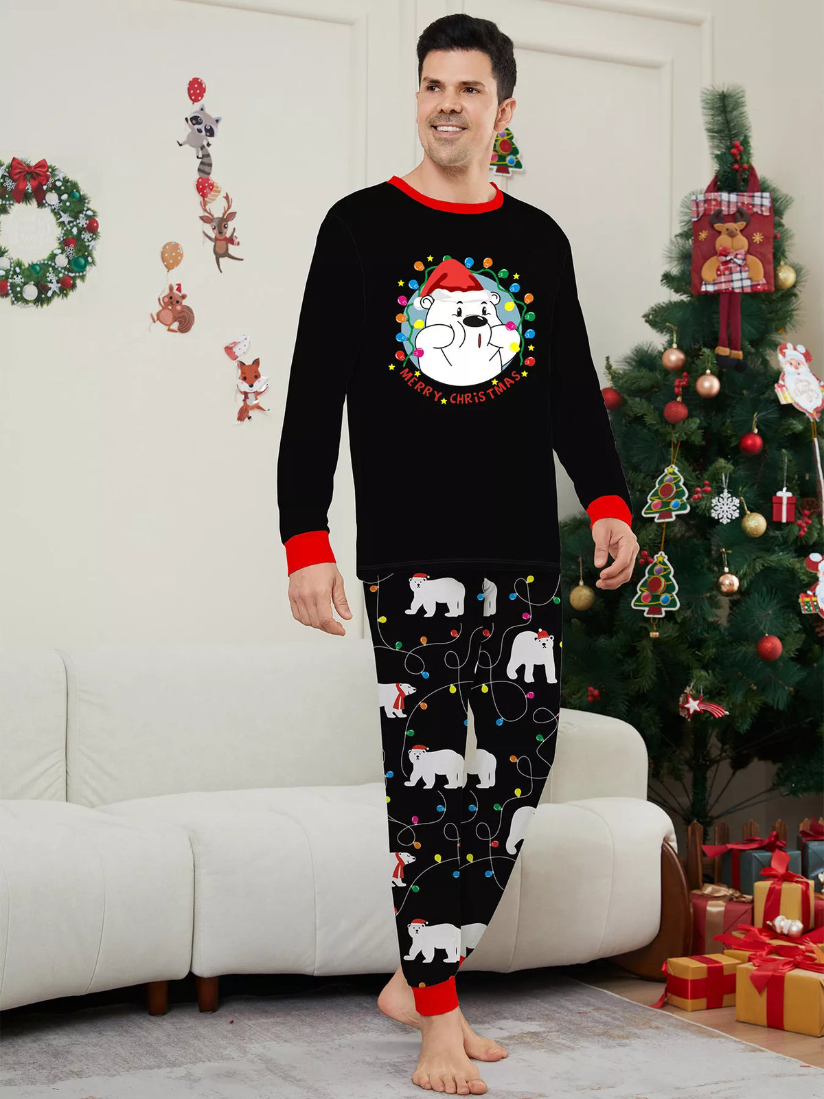 Man modeling a black Christmas graphic top and black polar-bear-print pajama pants.