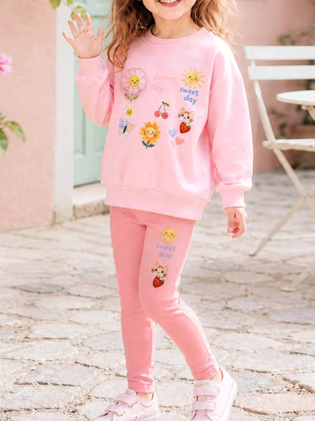 Children’s pink graphic sweatshirt and matching leggings worn by a child