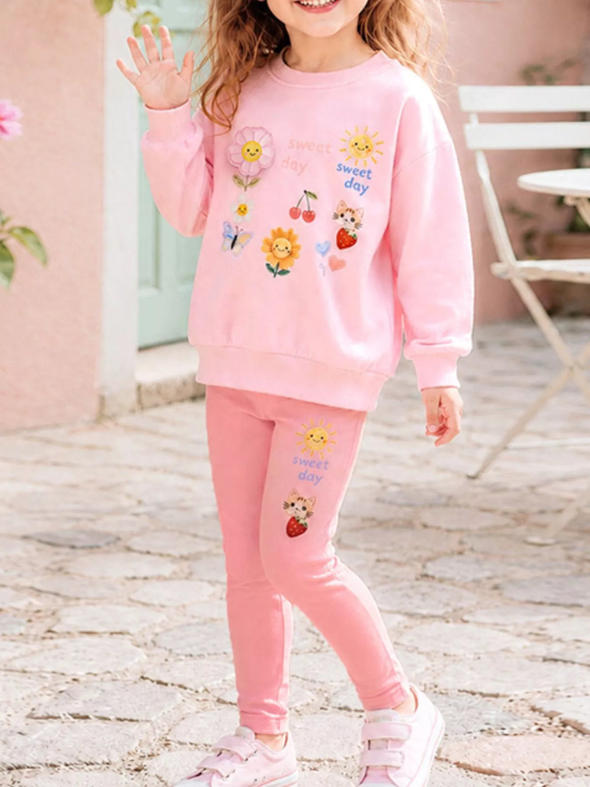 Children’s pink graphic sweatshirt and matching leggings worn by a child