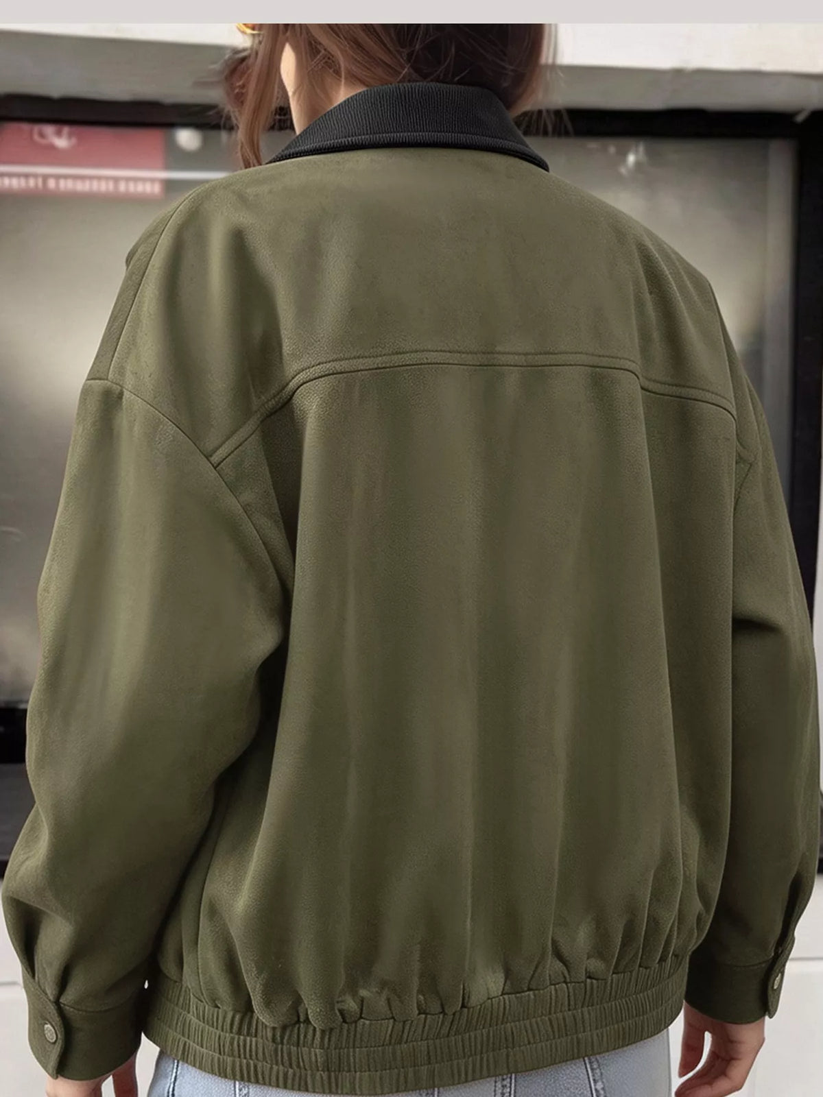 Back view of the army-green jacket with a gathered hem.