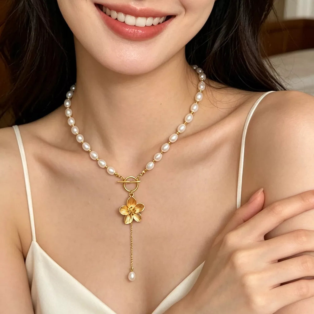 Pearl-like bead choker with gold-tone flower clasp and long pendant