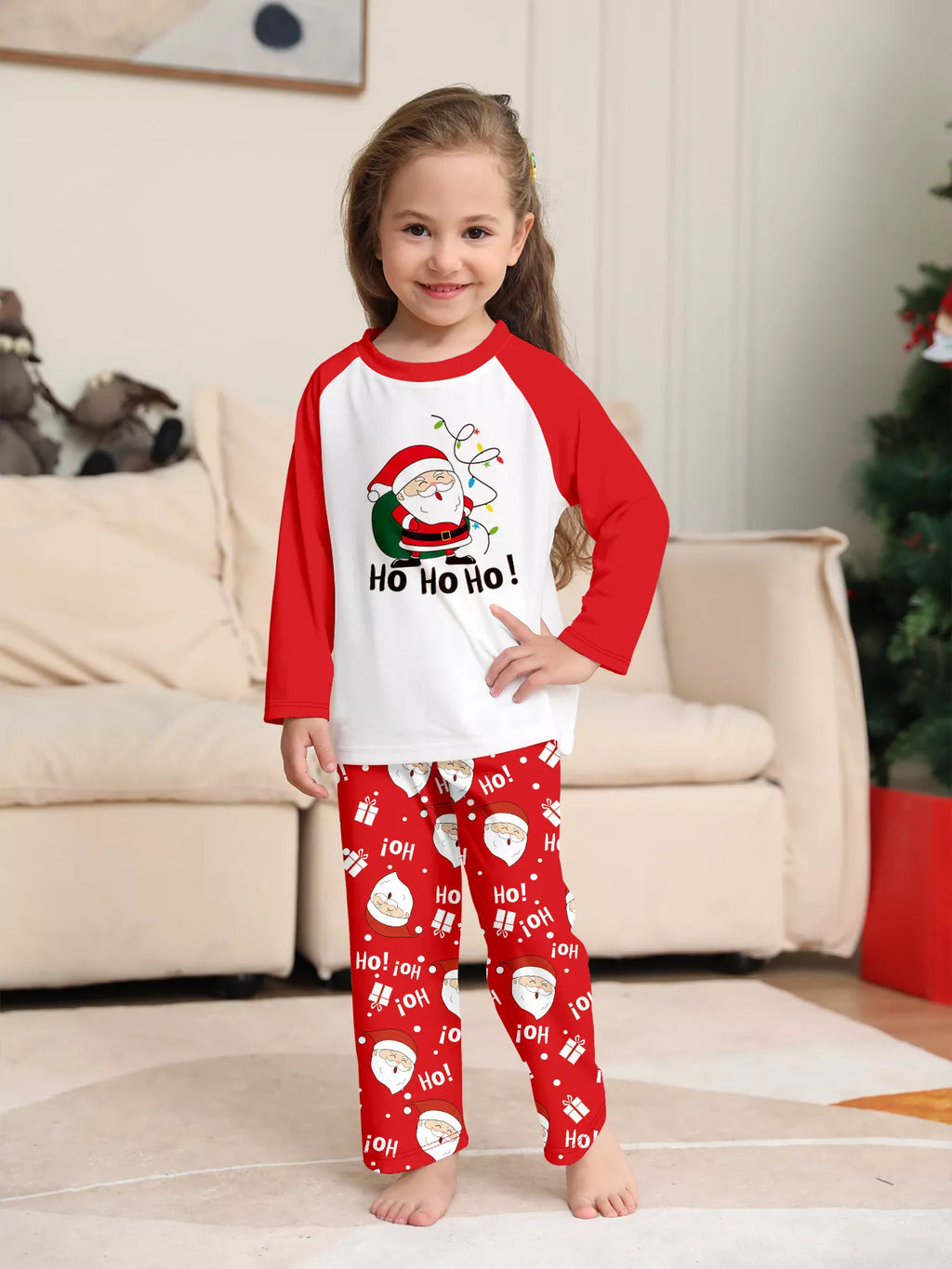 Child wearing the white Ho Ho Ho Santa top and red printed pants.