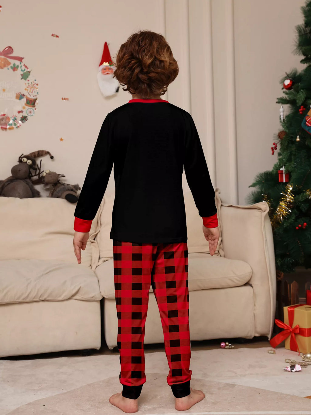 Back view of the children's black top and red plaid Christmas pajamas.