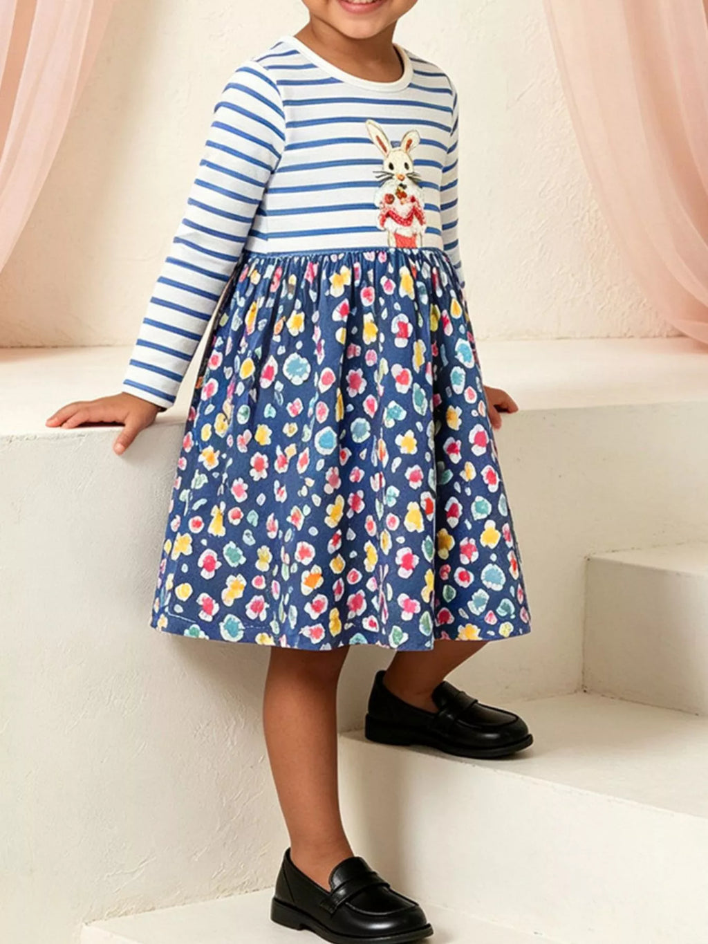 Blue and white striped bunny graphic dress with a dark floral skirt worn by a child