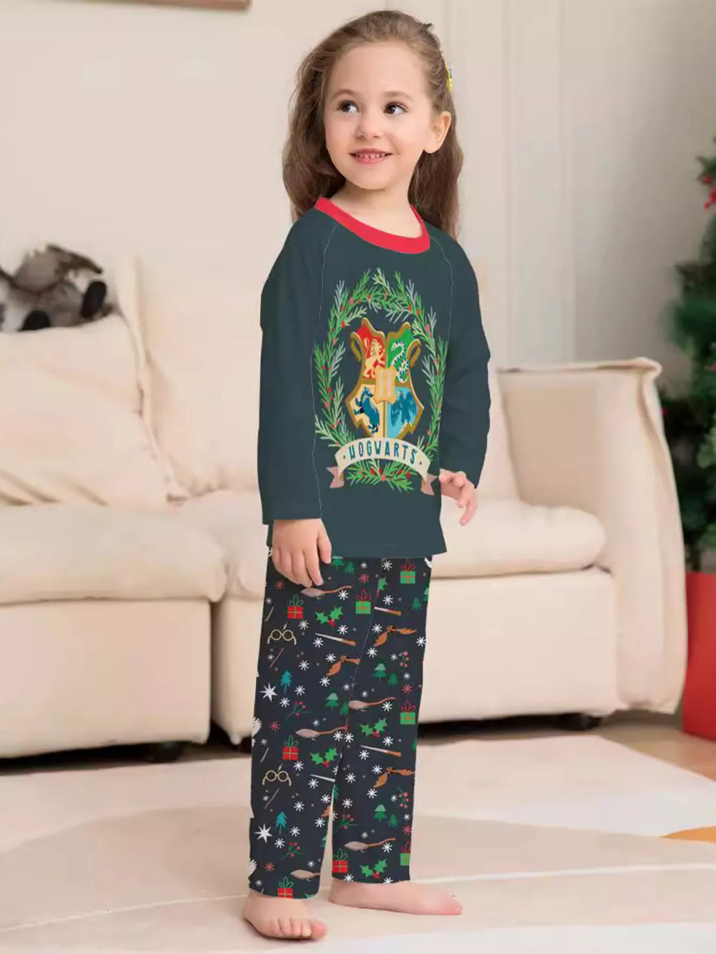 Dark green Hogwarts graphic pajama top with black patterned pants worn by a child