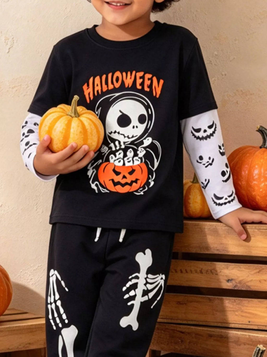 Children’s black Halloween skeleton graphic top and skeleton-print pants worn by a child