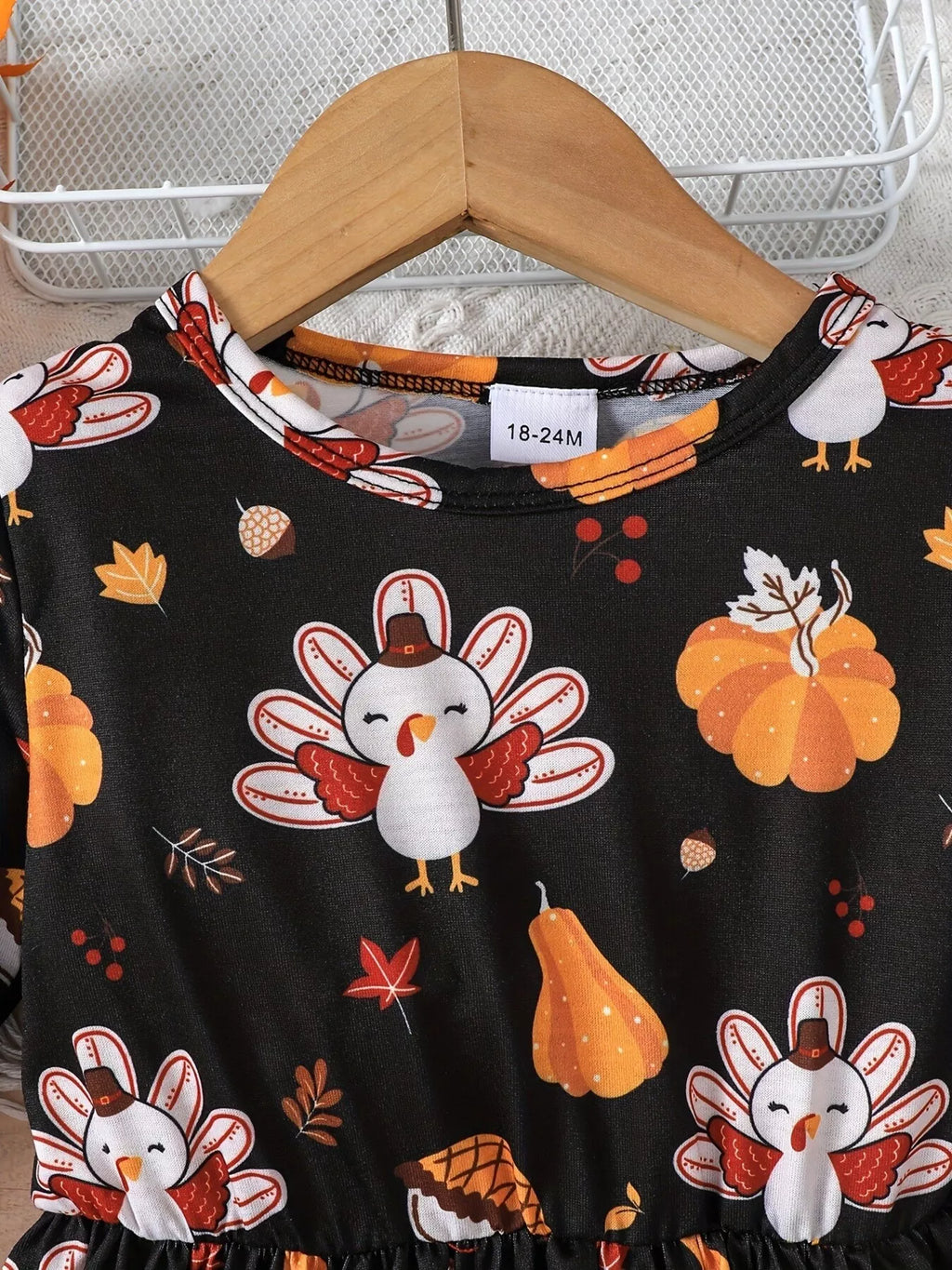 Turkey and autumn pumpkin print at the neckline of the black dress