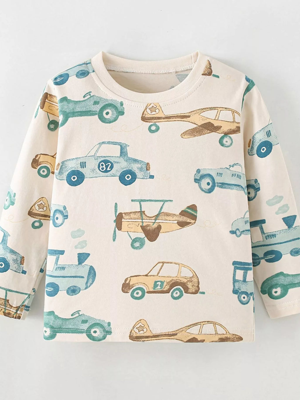 Front product view of the cream children's car-and-airplane print shirt.