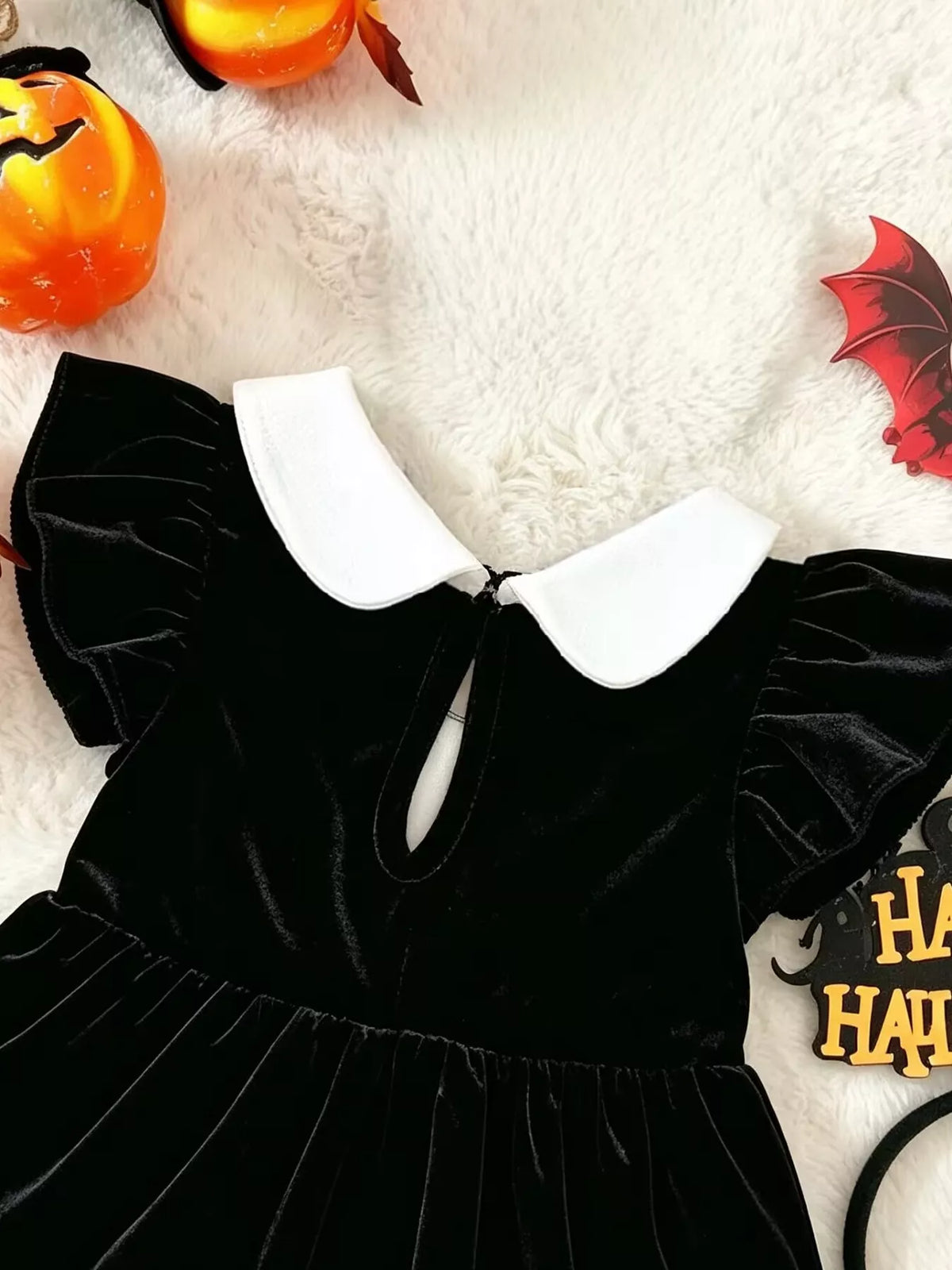 Close-up of the black romper's back neckline opening and white collar.