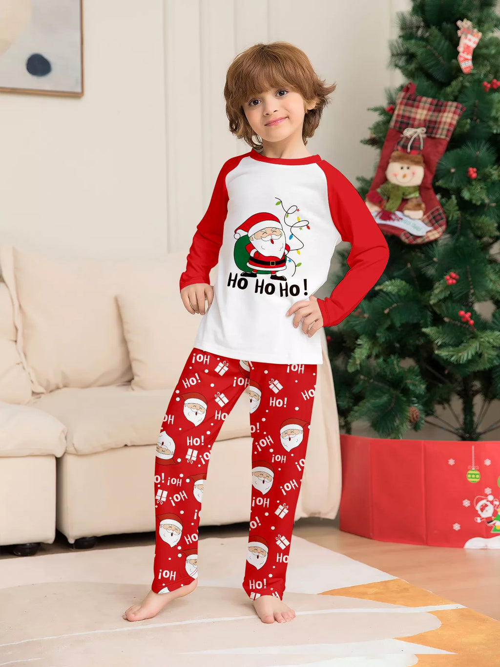 Child modeling the red-and-white Santa graphic pajama set.