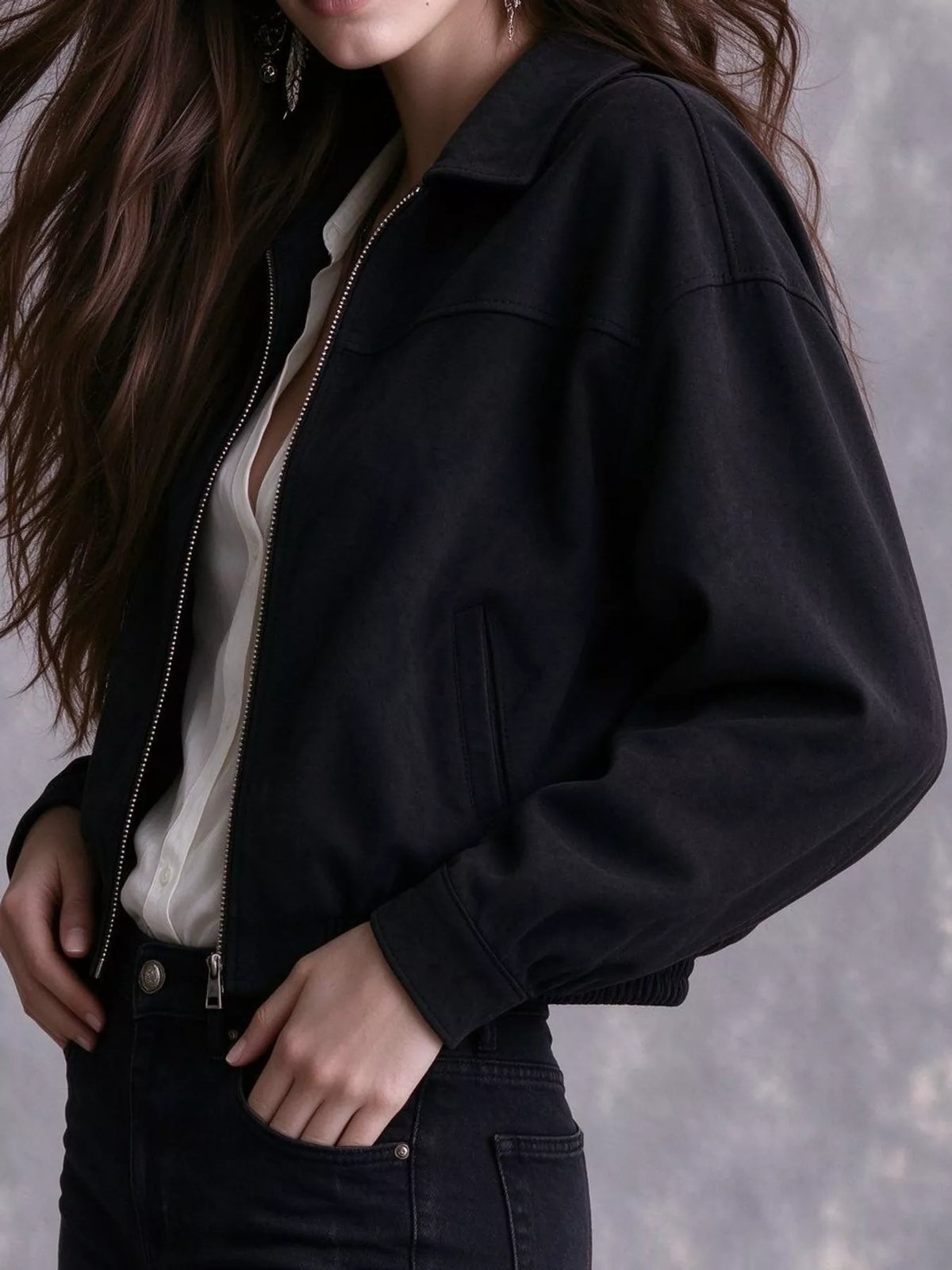 Angled view of the black bomber jacket's sleeve and pocket.