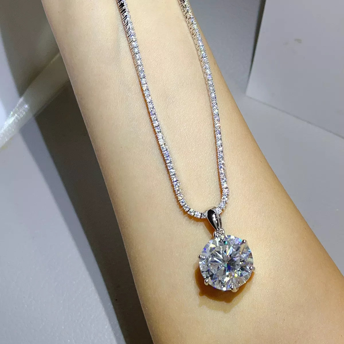 Silver-tone necklace with a round clear stone pendant — detail view