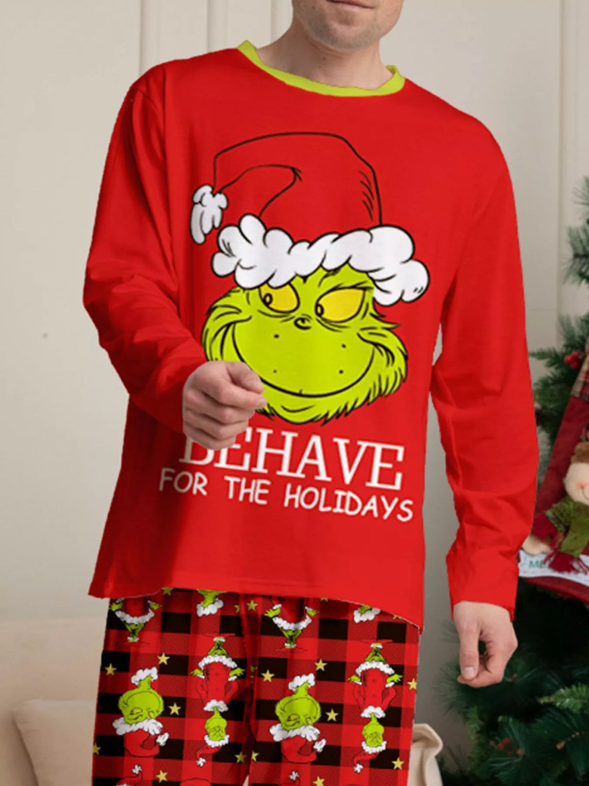 Grinch face graphic and holiday lettering on the red pajama top