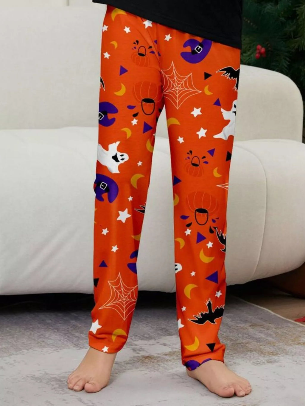 Close view of the orange ghost, bat and star-print pajama legs.