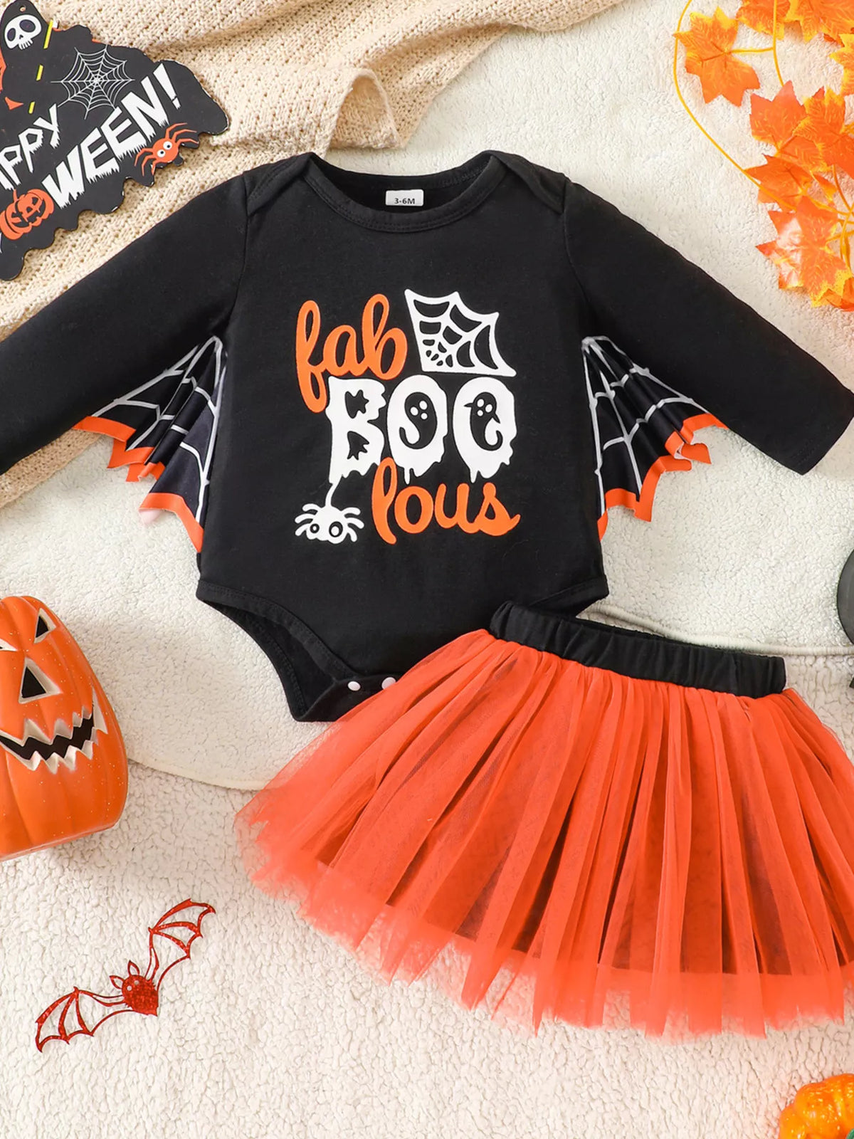 Flat lay of the black Halloween graphic bodysuit and orange tulle skirt.