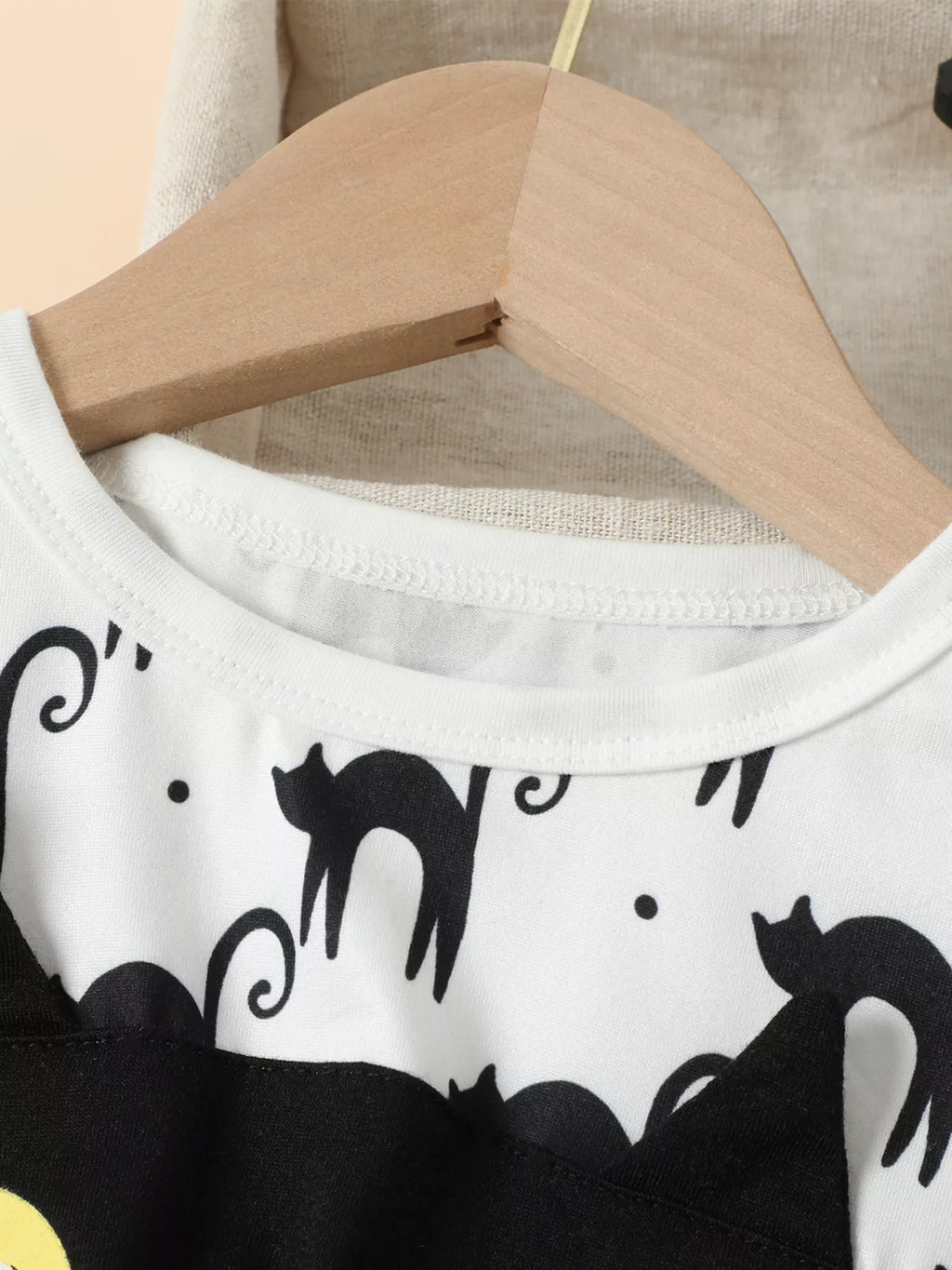 Close-up of the white dress neckline and black cat print.