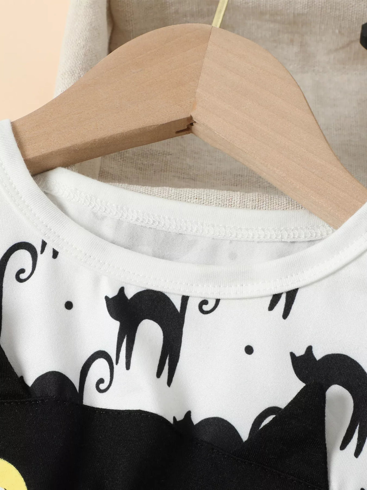 Close-up of the white dress neckline and black cat print.