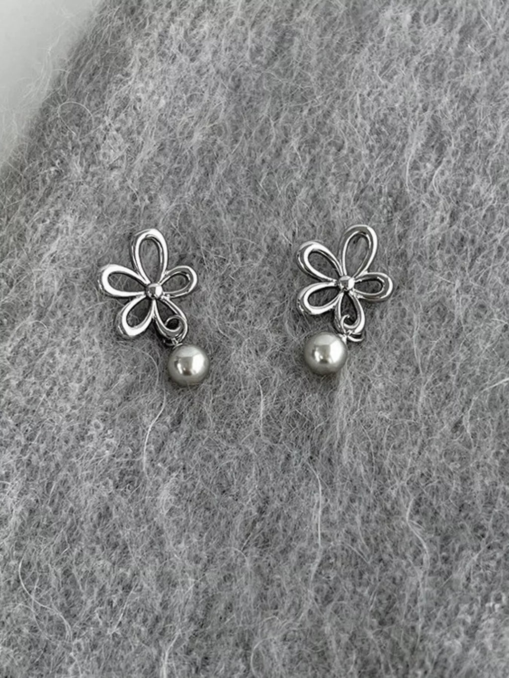 Flower-shaped drop earrings with pearl-like beads — detail view