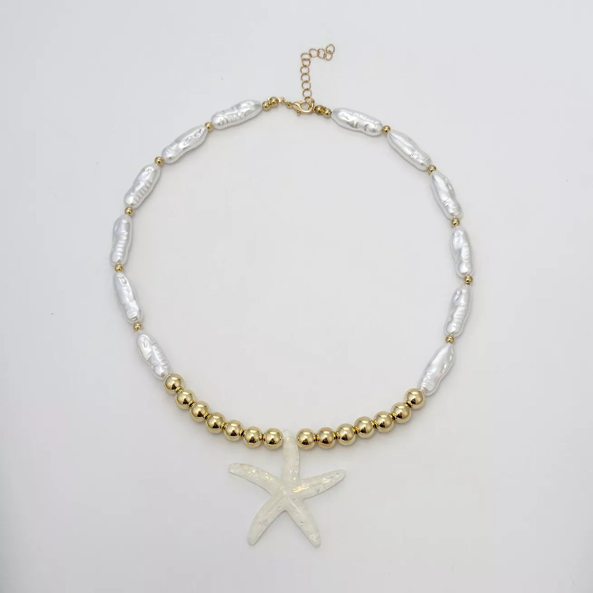 Starfish pendant necklace with gold-tone beads and white shell-like links