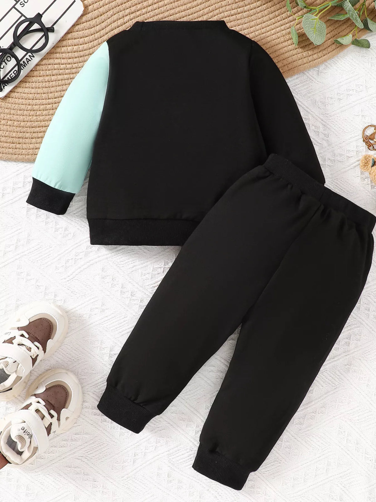 Black, orange and mint color-block sweatshirt and matching joggers laid flat