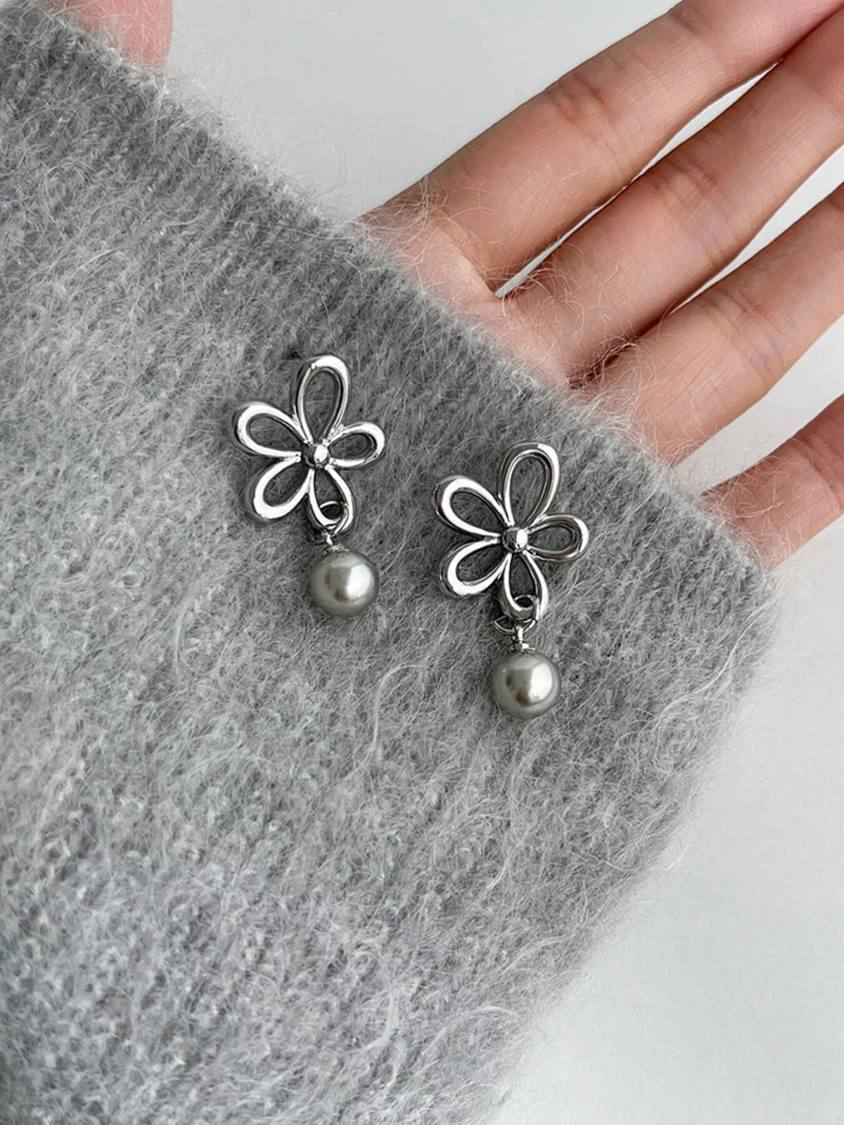 Flower-shaped drop earrings with pearl-like beads — detail view