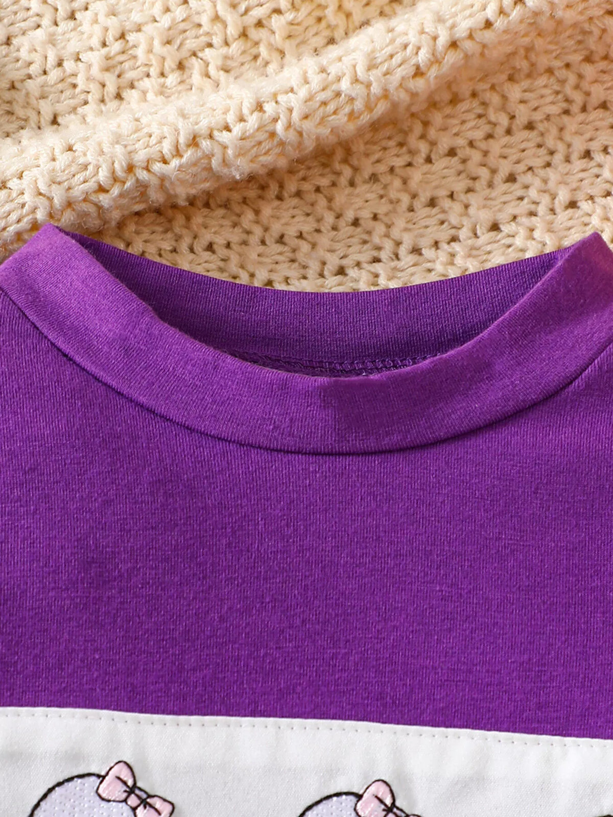 Close-up of the purple top's crew neckline.