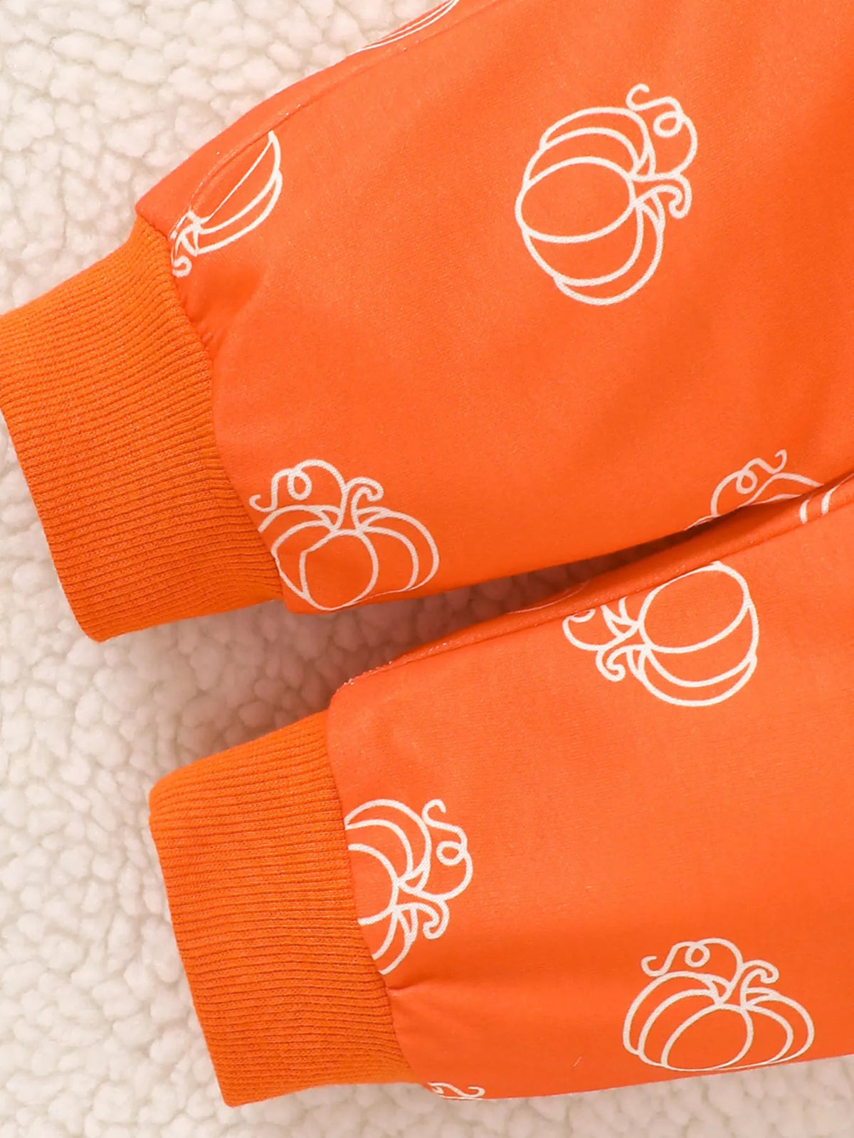 White pumpkin outline pattern and cuff on orange fabric