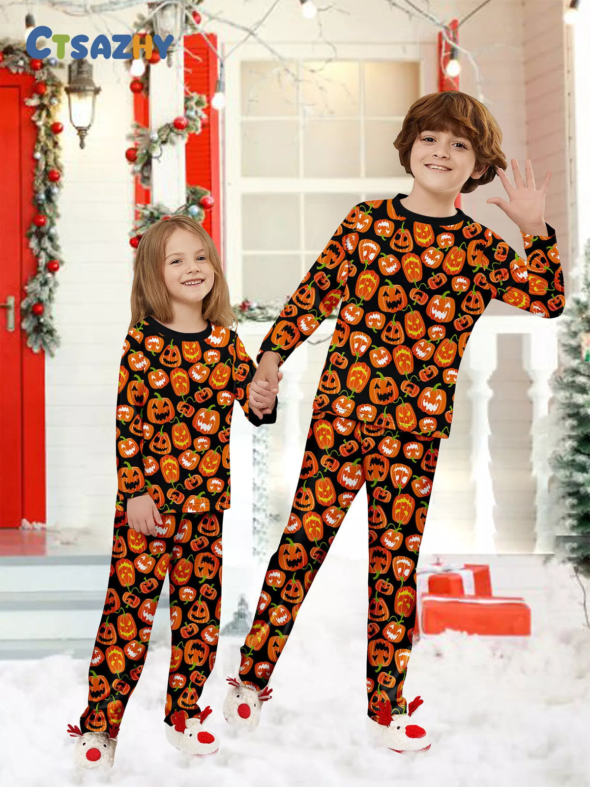 Two children wearing matching black and orange pumpkin-print pajamas.