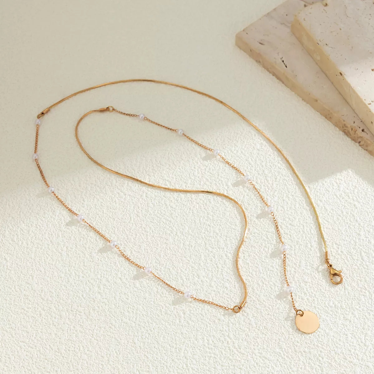 Gold-tone pearl-like station necklace with coin pendant — detail view