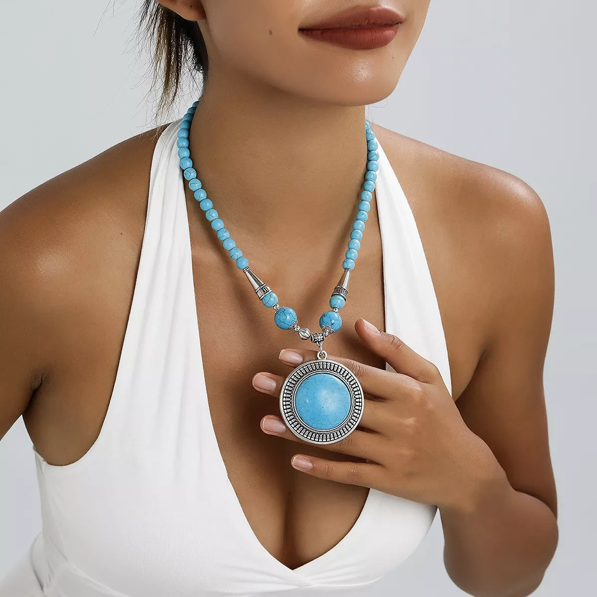 Turquoise-colored round medallion pendant necklace with large beads