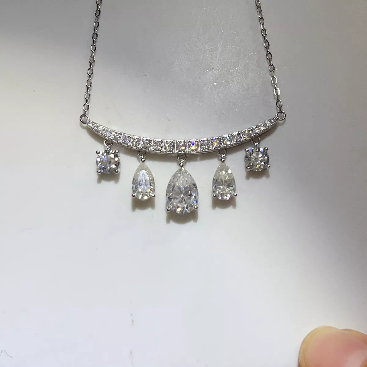 Silver-tone necklace with graduated teardrop stone pendants — detail view