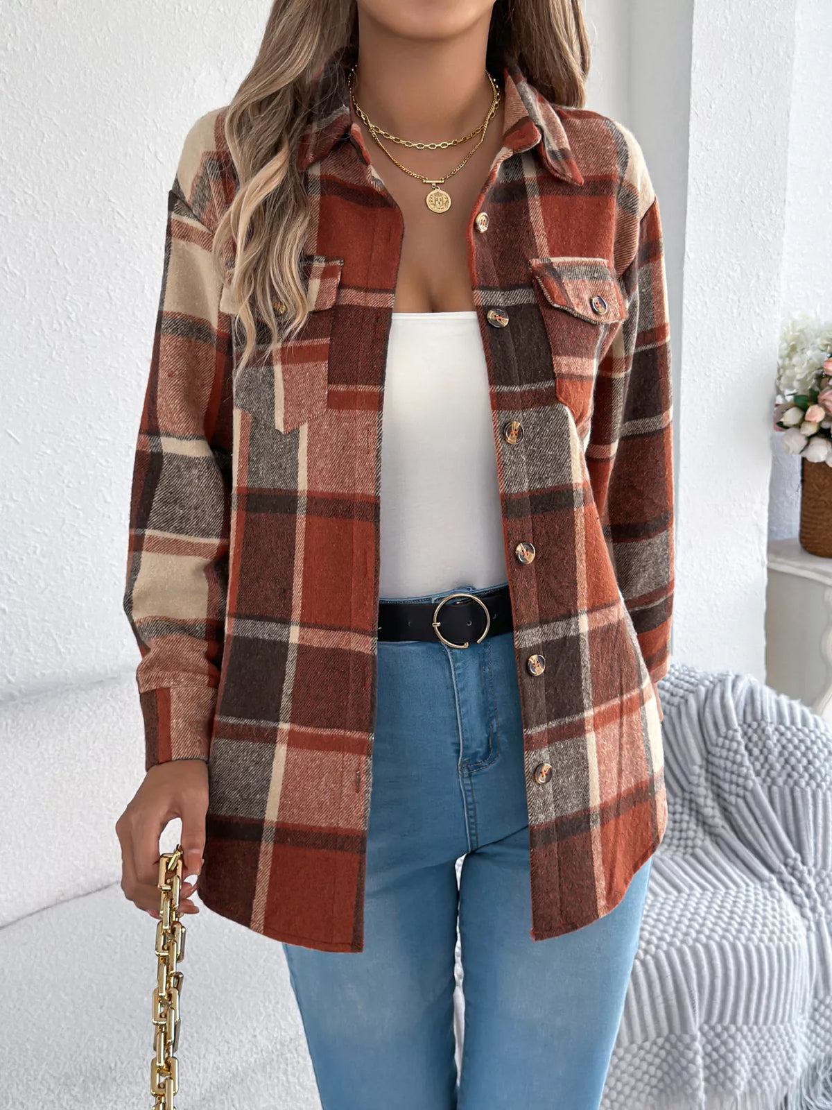 Orange plaid button-down shacket with chest pockets, worn open over a white top.