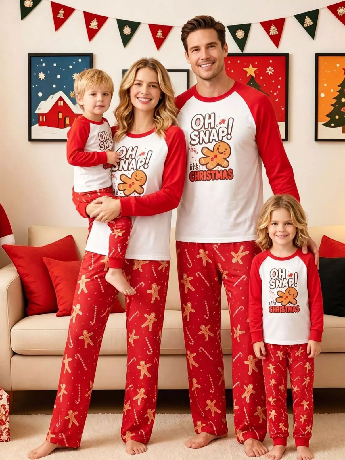 Family wearing matching white Oh Snap gingerbread graphic tops with red sleeves and red printed pajama pants.