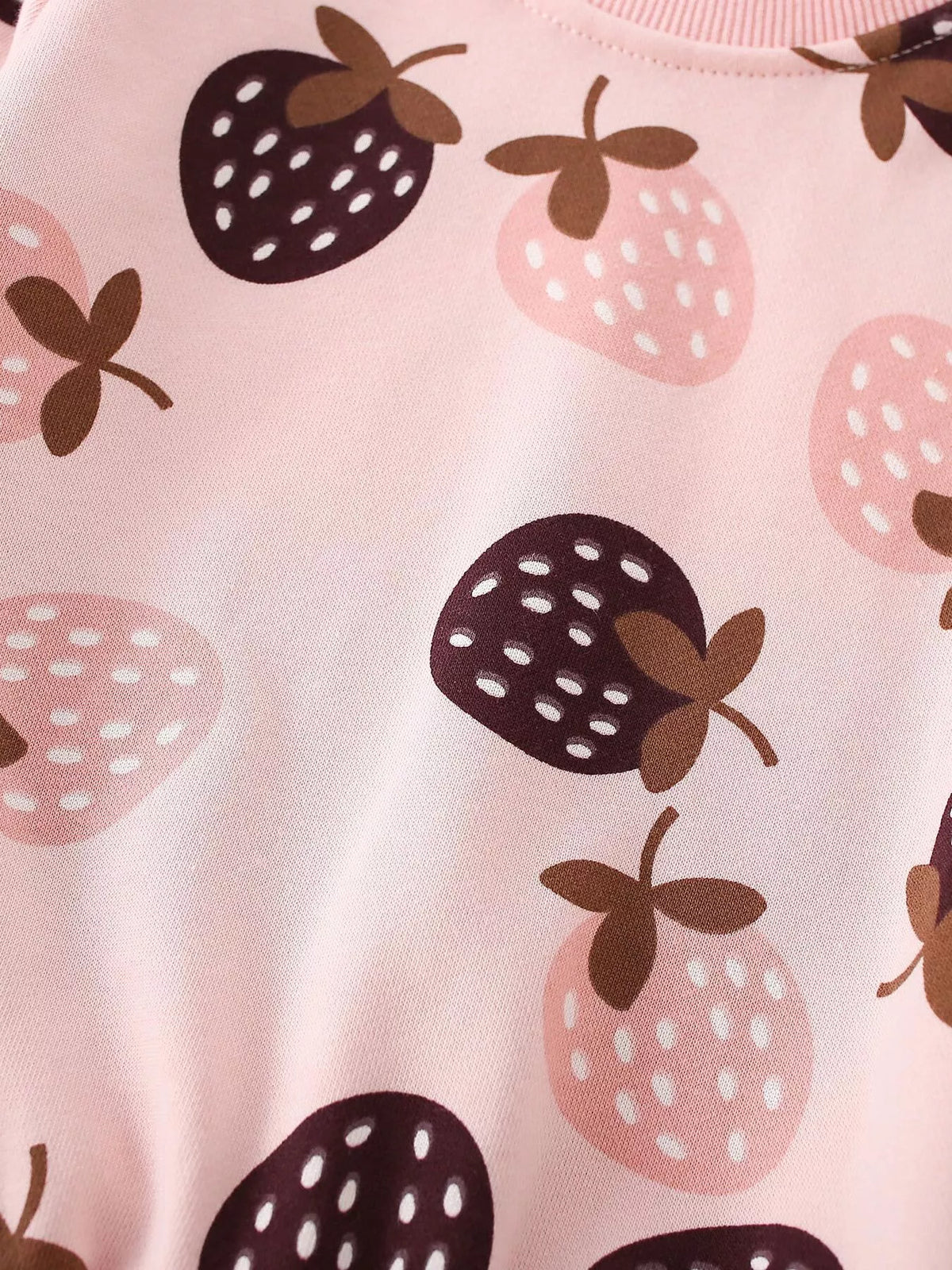 Close-up of the pink sweatshirt's allover strawberry print.