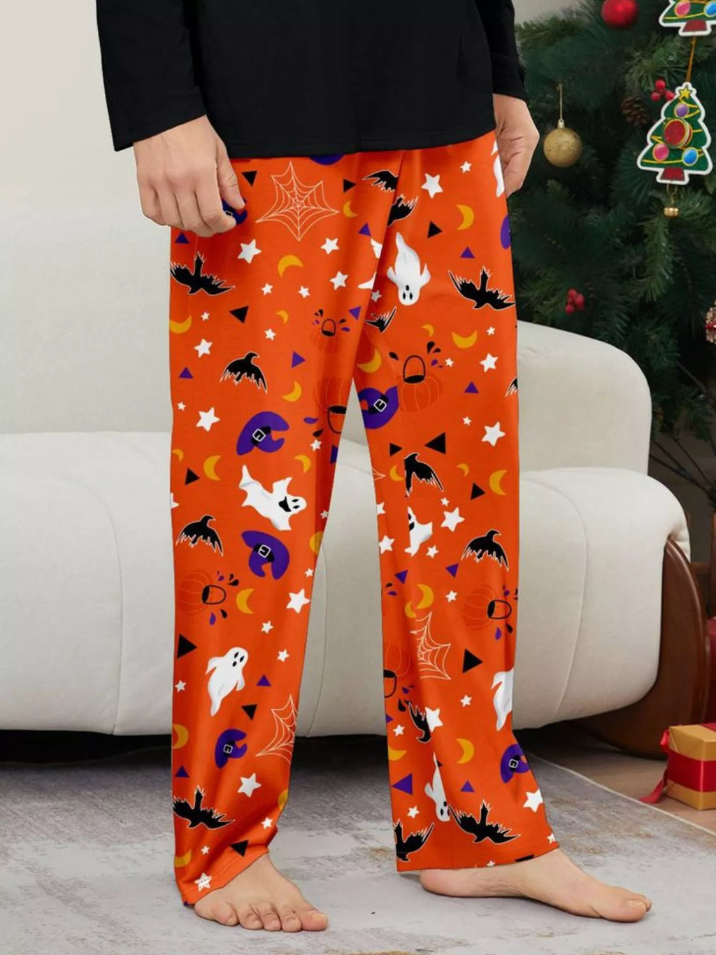 Close view of orange pajama pants with ghosts, bats, stars and purple Halloween prints.
