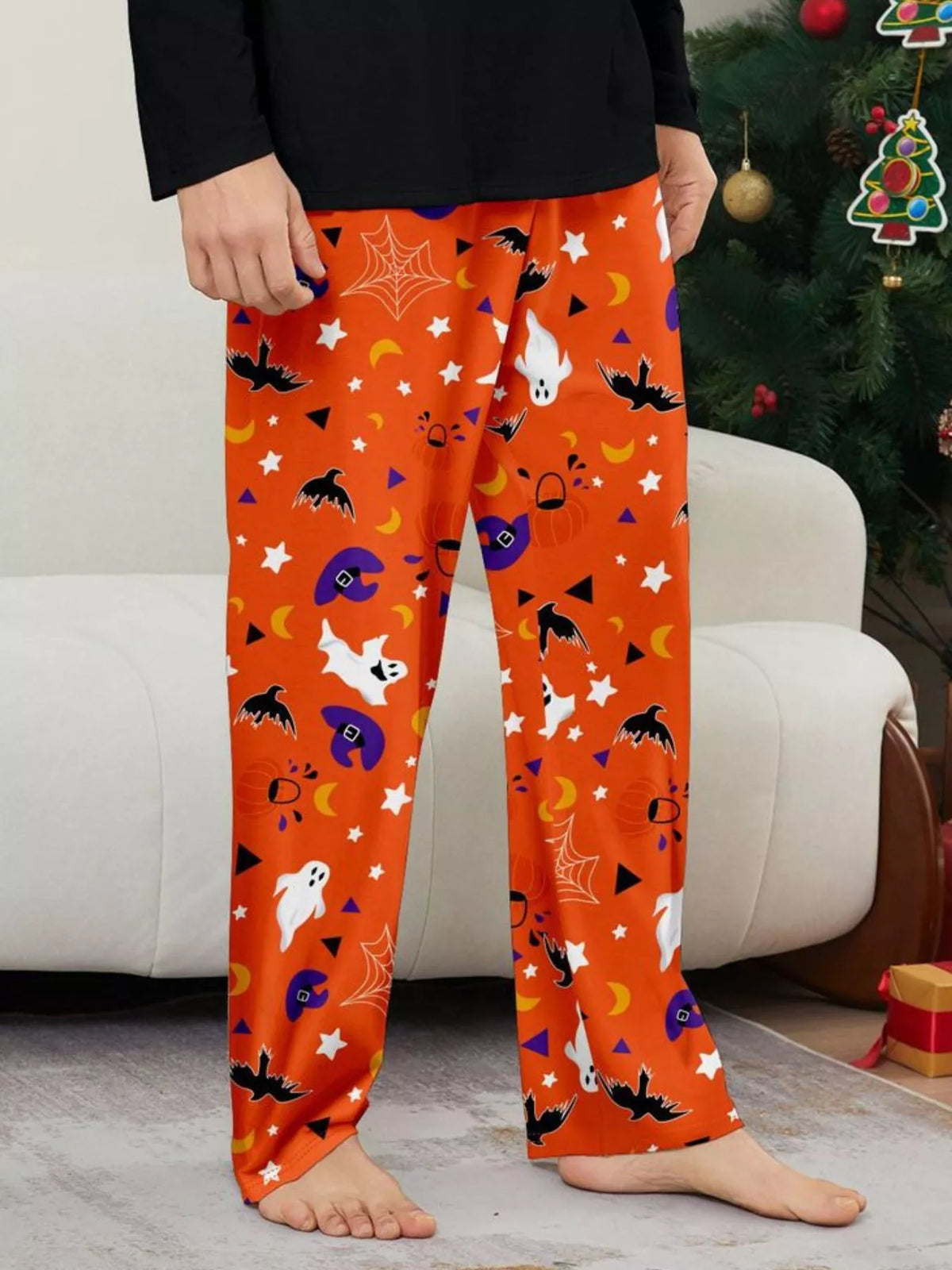Close view of orange pajama pants with ghosts, bats, stars and purple Halloween prints.