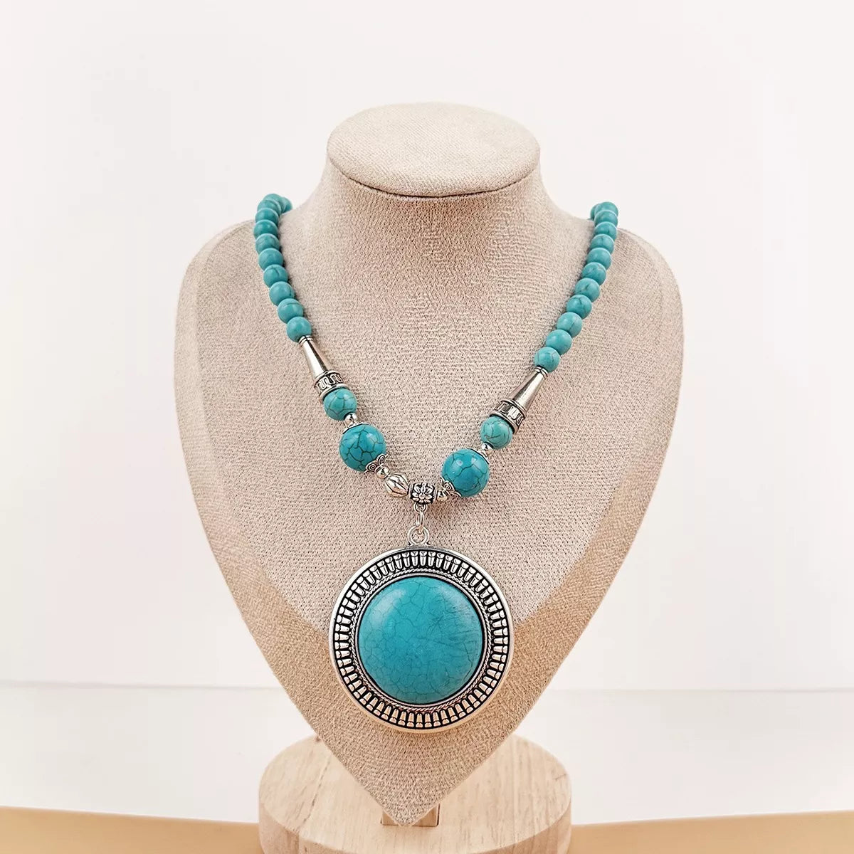 Turquoise-colored round medallion pendant necklace with large beads