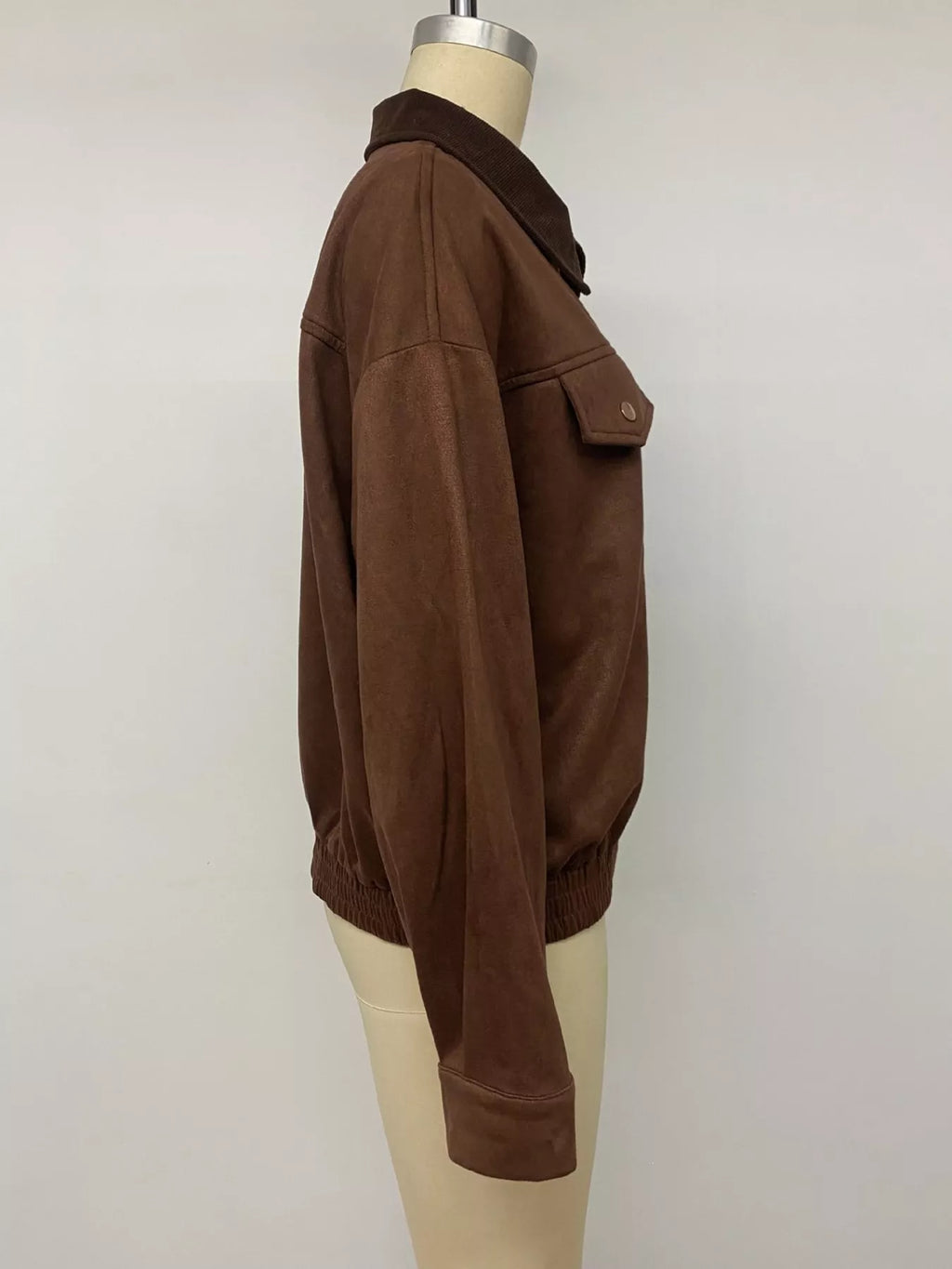 Side view of the brown jacket on a mannequin.