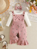 White ribbed baby bodysuit with pink bow-accented overalls and matching headband displayed flat
